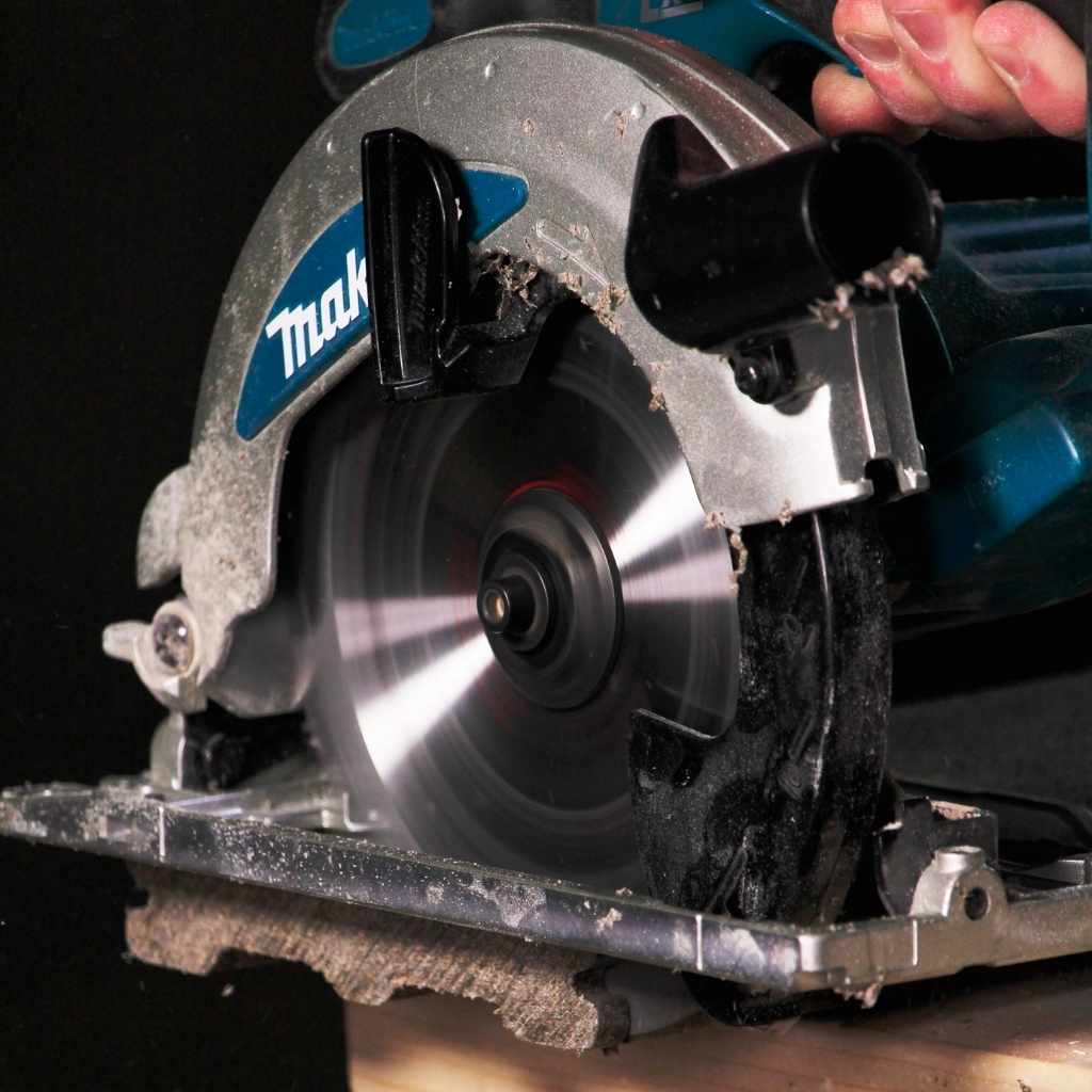 Close-up of a circular saw with a visible Makita brand logo on a dark background